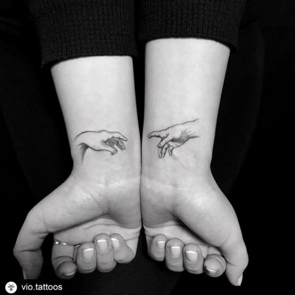 Adam hands on each of wrist tattoo