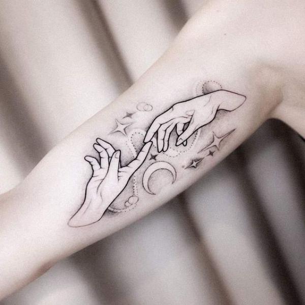 Adam hands with moon and stars tattoo