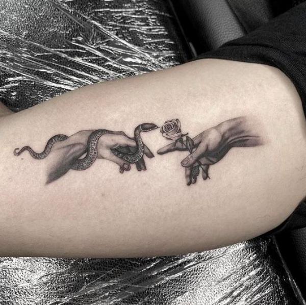 Adam hands with snake and rose tattoo