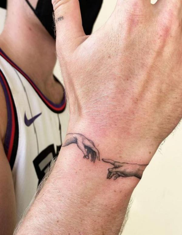 Adam hands wrist tattoo