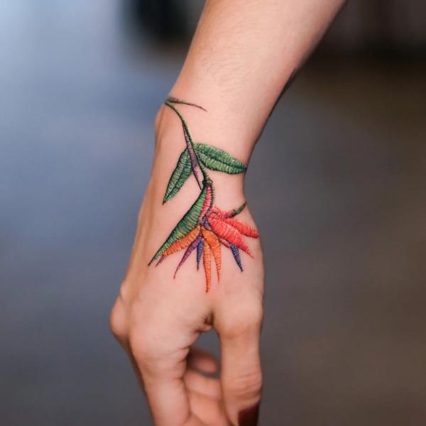 Bird of paradise patch tattoo on hand