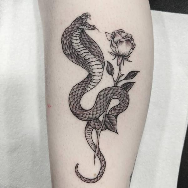 Black and grey cobra and rose with stem tattoo