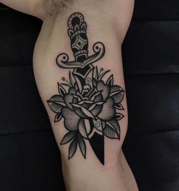 Black and grey rose and dagger bicep tattoo