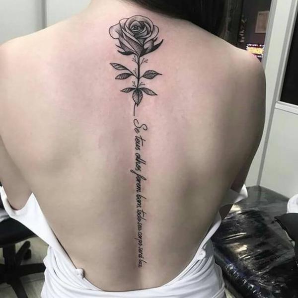 Black and grey rose tattoo with quote along spine