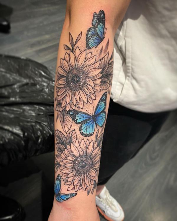 Black and grey sunflowers and blue butterflies tattoo forearm