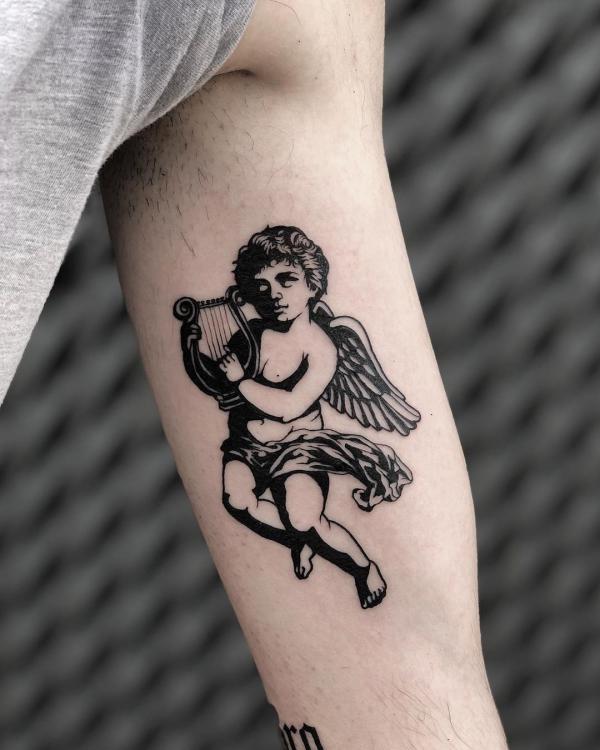 Black and white cherub playing harp tattoo