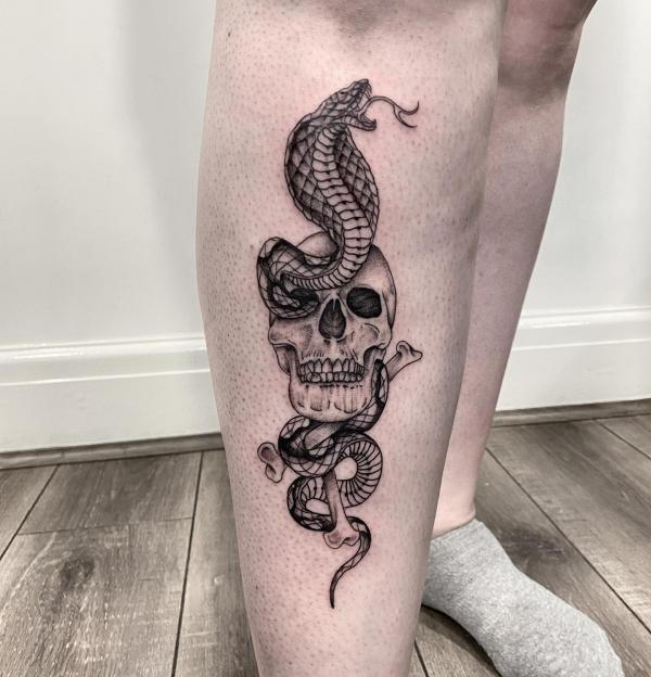 Black and white cobra entwined with skull and bones