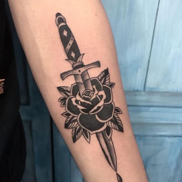 Black and white traditional rose and dagger tattoo