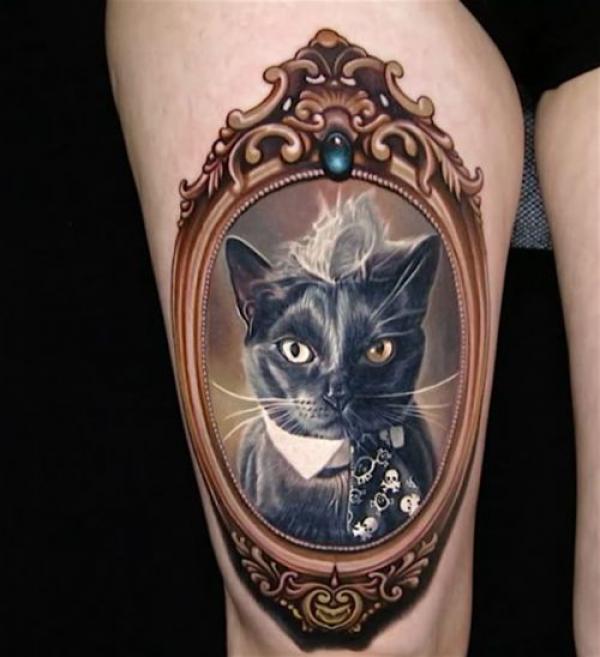 Black cat photo frame tattoo on thigh