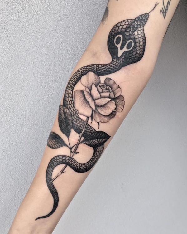 Black cobra and rose with thorns tattoo on forearm