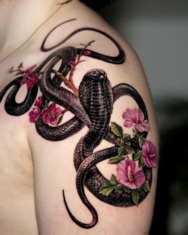 Black cobra with pink flower shoulder tattoo