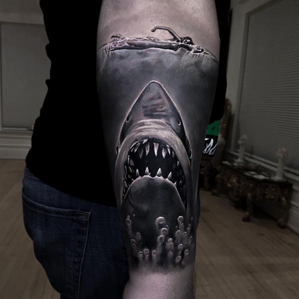 Blackwork shark and swimmer tattoo