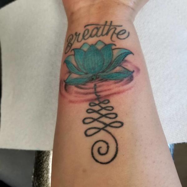 Blue lotus with the Unalome Symbol and the word Breathe tattoo