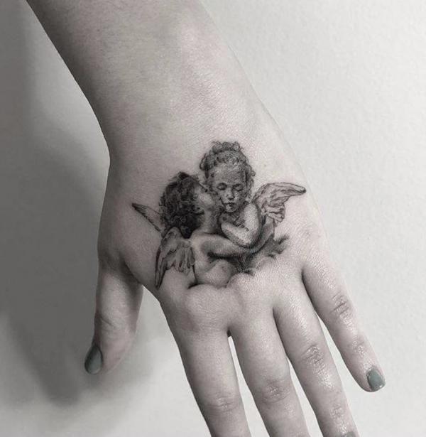 Boy and girl cherub hand tattoo