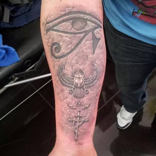 Carved in stone eye of Ra and scarab tattoo
