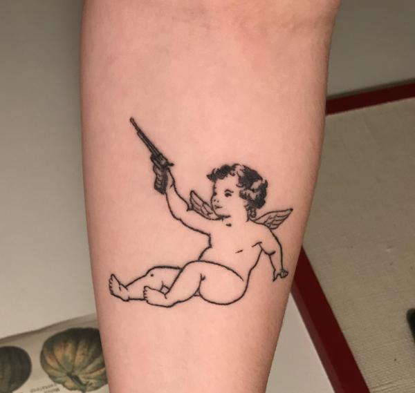 Cherub with a pistol tattoo