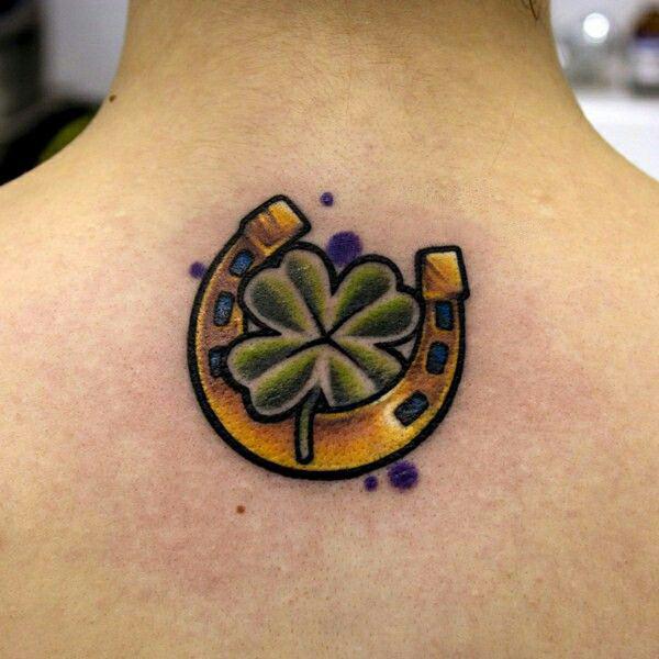 Clover and horseshoe tattoo on upper back