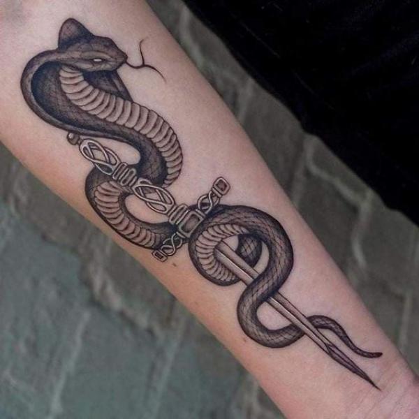 Cobra and dagger tattoo on forearm