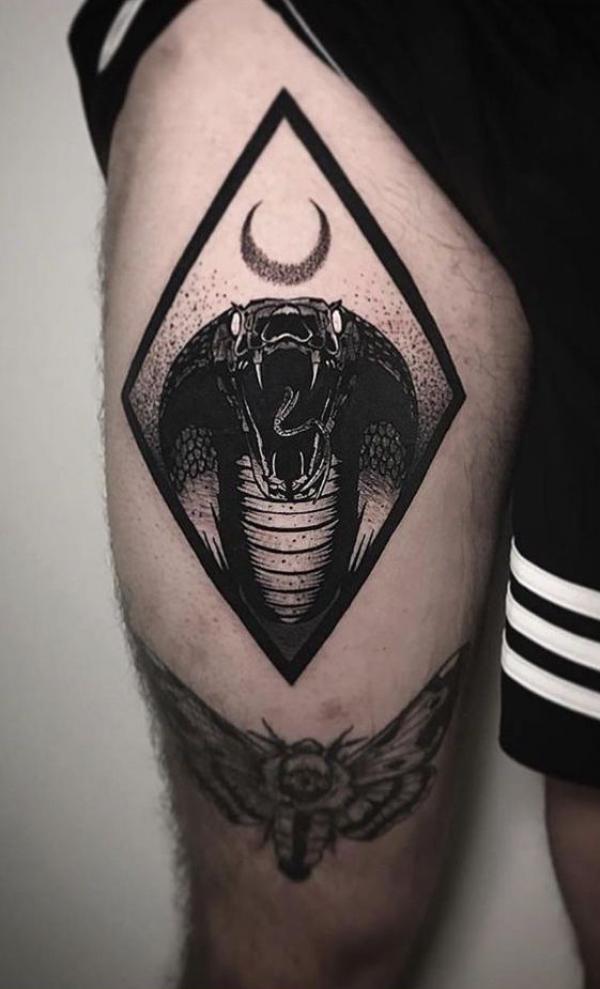 Cobra head and crescent moon tattoo on thigh