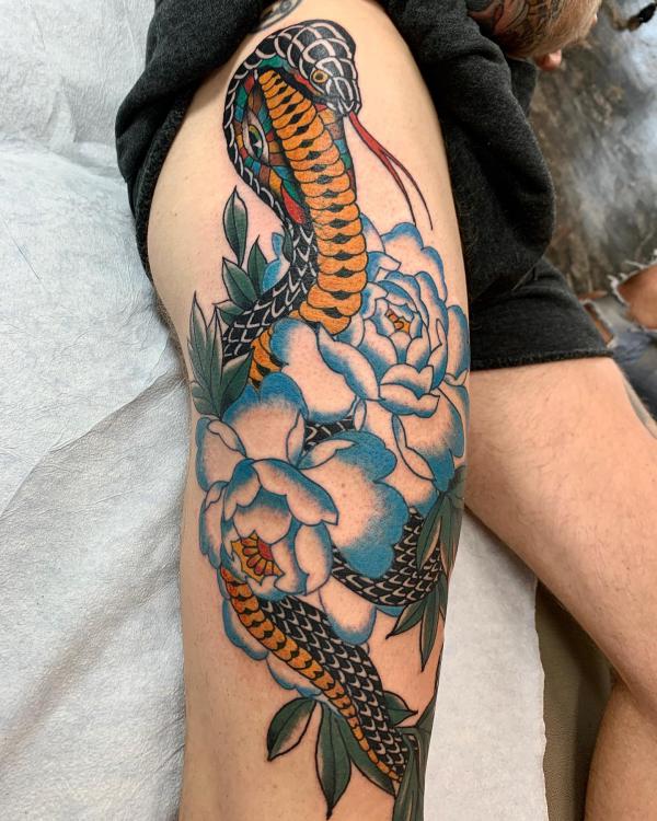 Cobra with blue and white rose tattoo on the side of thigh