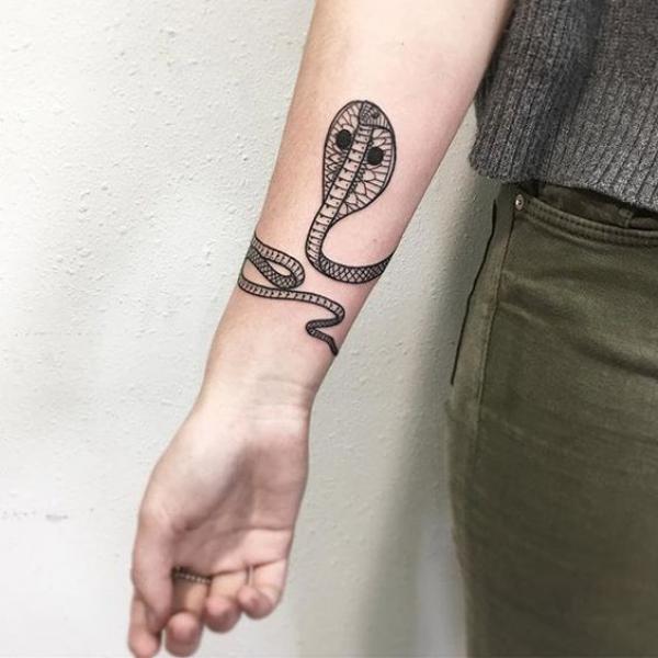 Cobra wrapping around wrist tattoo