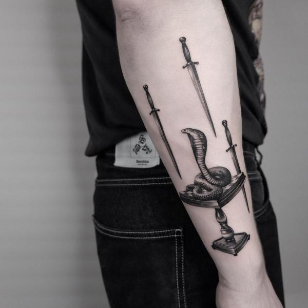 Coiled cobra and falling swords tattoo