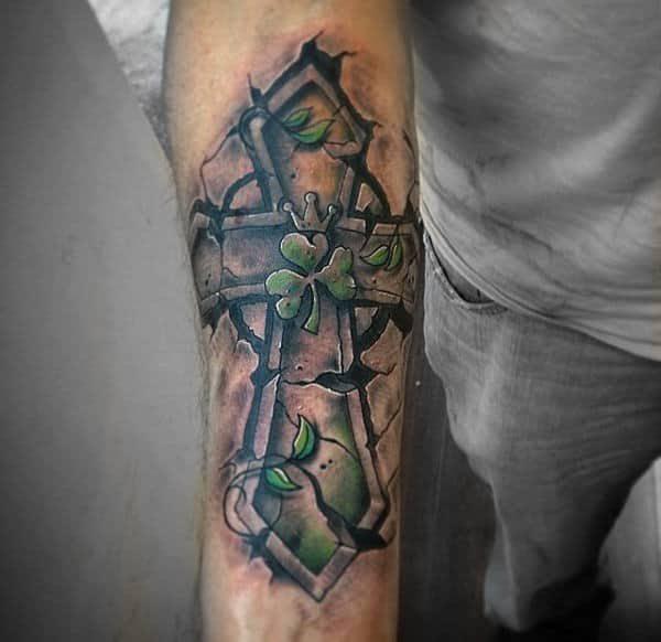 Cross and shamrock carved tattoo on forearm