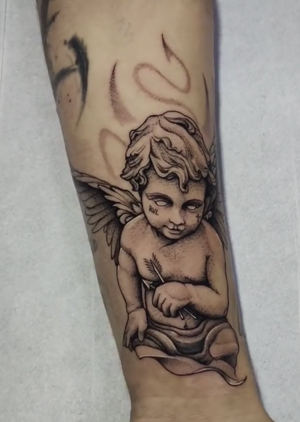 Evil cherub forearm tattoo