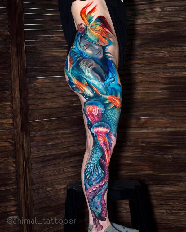 Female face with gold fish and jellyfish tattoo