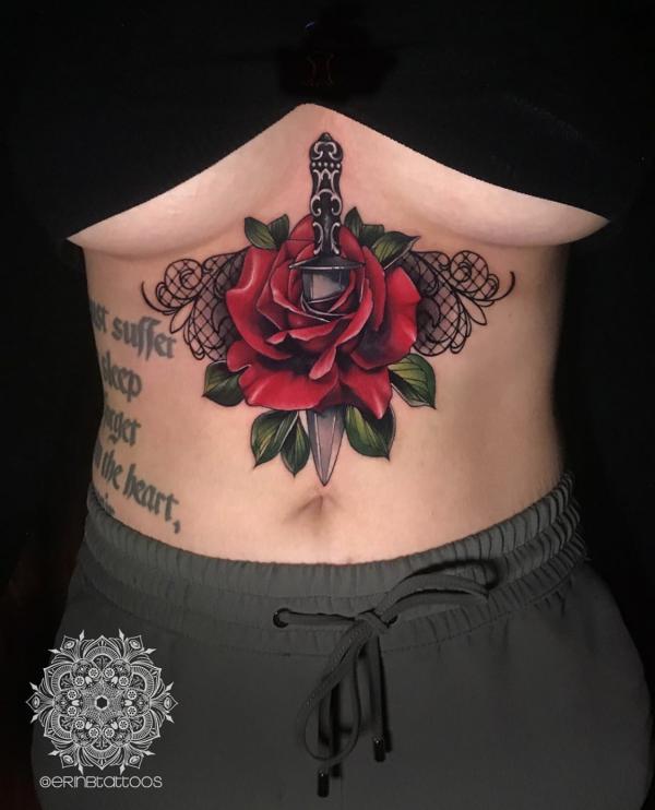 Feminine red rose and dagger sternum tattoo