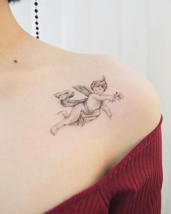 Flying Cherub holding flower tattoo