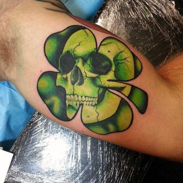 Four leaf shamrock skull tattoo on bicep