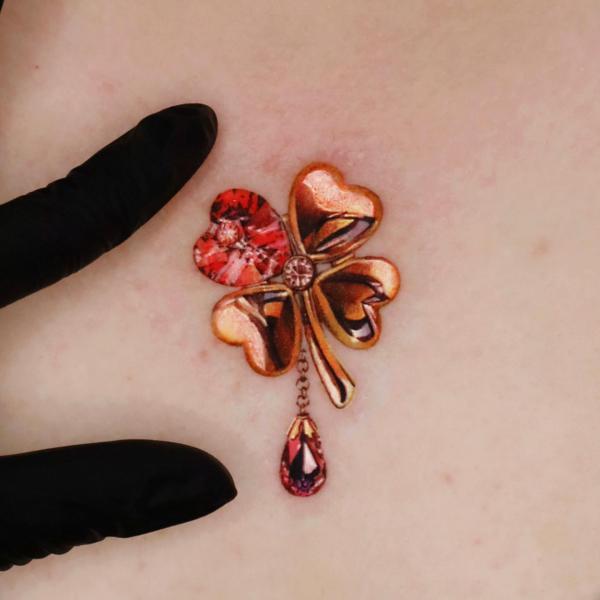 Golden four leaf clover with love petals and diamond tattoo