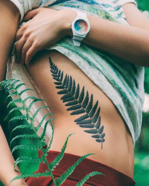 Green fern rib tattoo