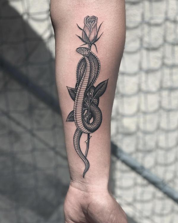 Greyscale cobra wrapping around rose with stem tattoo