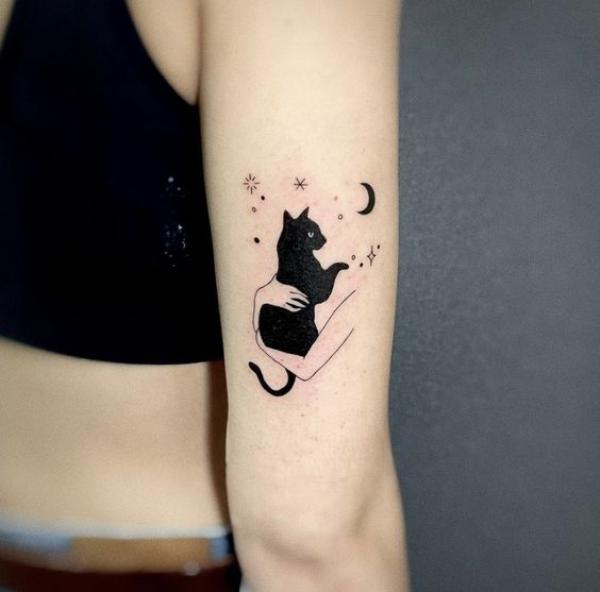 Holding a black cat with moon and stars