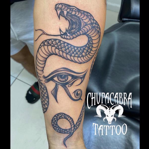 Horus eye and snake tattoo