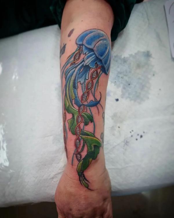 Jellyfish with DNA strand forearm tattoo
