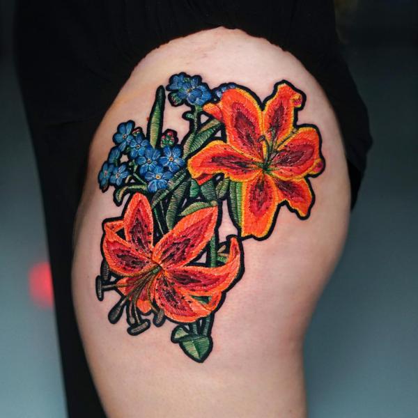 Lily and forget me not patch tattoo on thigh