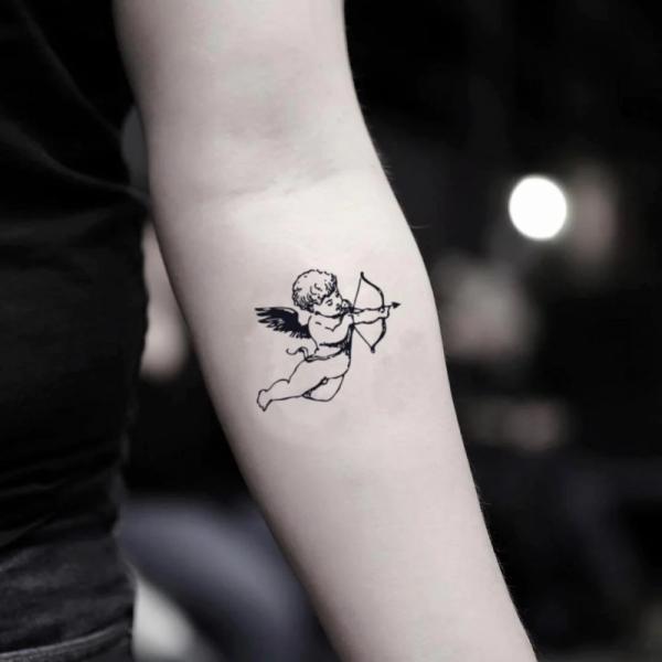 Minimalist cupid cherub tattoo below inner elbow