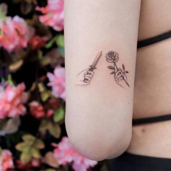 Minimalist dagger and rose tattoo