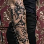 Praying cherub forearm tattoo