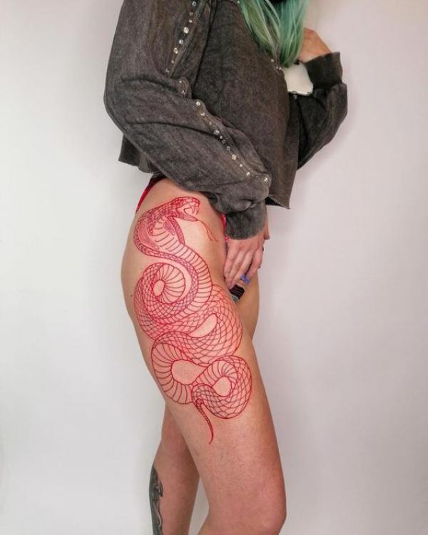 Red fine line cobra tattoo on the side of hip