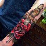 Rose and dagger arm tattoo traditional