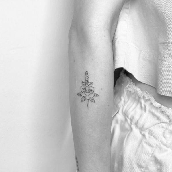 Rose and dagger line work tattoo