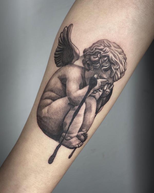 Sad cherub tattoo