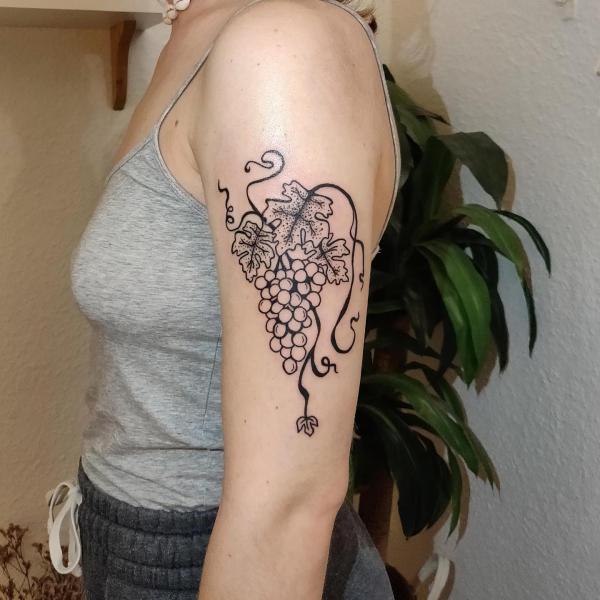 Simple grapes with leaves tattoo on upper arm