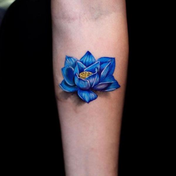 Single blue lotus tattoo on forearm