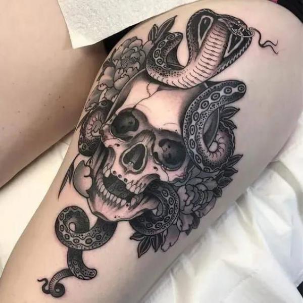 Skull with cobra and peony thigh tattoo