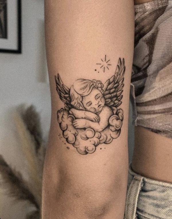 Sleeping cherub with star tattoo
